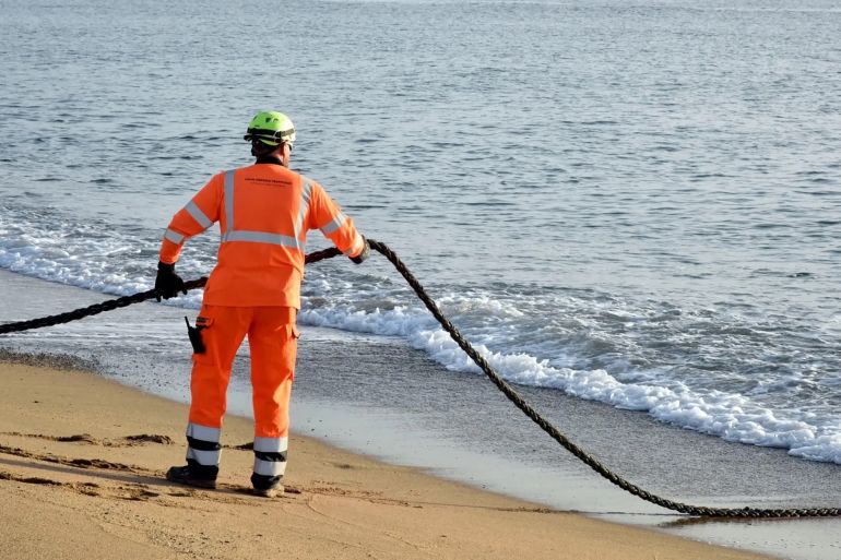 SANT ADRIA DE BESOS, BARCELONA, , SPAIN - OCTOBER 25: A worker with the 2Africa submarine cable as it arrives at the Barcelona Cable Landing Station (CLS) in Sant Adria de Besos, on 25 October, 2022 in Sant Adria de Besos, Barcelona, Catalonia, Spain. Meta announced yesterday, Monday, October 24, in a statement that the consortium has partnered with Barcelona-based AFR-IX to carry out the cable mooring in the city. This is the longest submarine cable ever deployed at 45,000 kilometers and will serve communities that rely on the Internet to provide services. The deployment will enable companies and service providers located in Spain to access international connectivity from the company's facilities with a direct connection to the cable mooring station. (Photo By David Oller/Europa Press via Getty Images)
