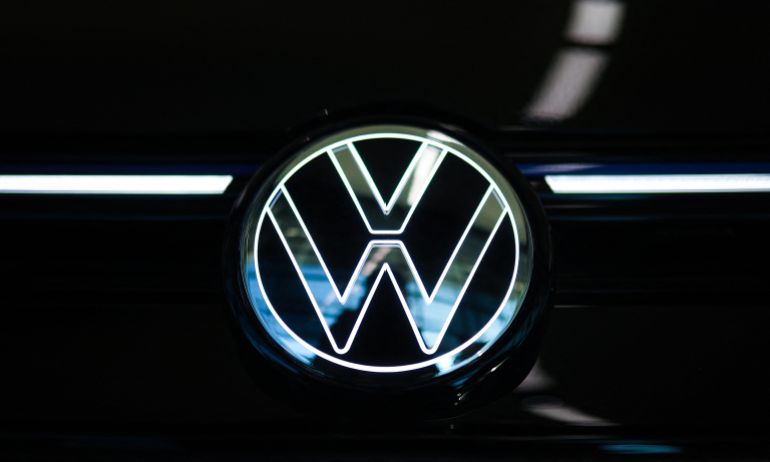 (FILES) The illuminated VW Logo of German car manufacturer Volkswagen (VW) is seen on a new Golf car in the customer centre at the carmaker's headquarters in Wolfsburg, central Germany, on November 21, 2025.