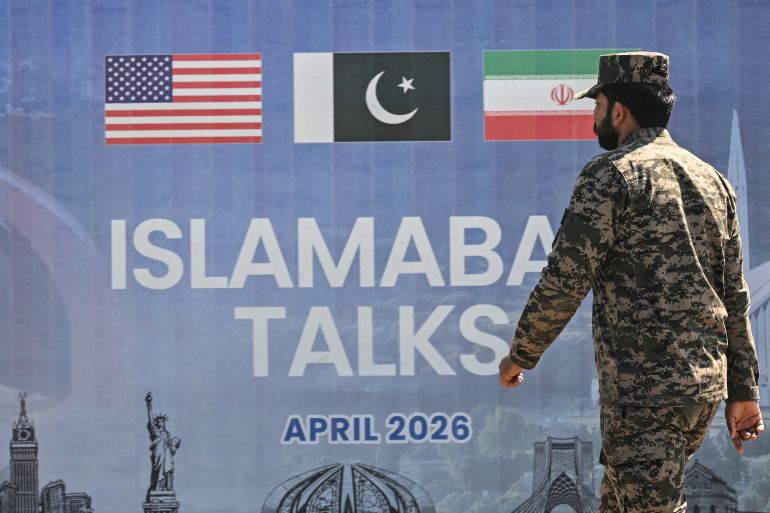 afp_69dd13691e90-1776096105-1 A Pakistani Ranger walks past a billboard for the US-Iran peace talks in Islamabad on April 12, 2026.