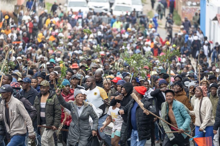 Protesters walk in street during a protest march against undocumented migrants in Yeoville, Johannesburg, on April 30, 2026. (Photo by Wikus de Wet / AFP)