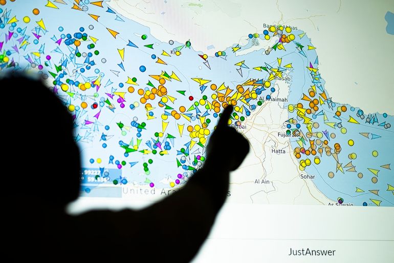 A photo illustration taken in Nicosia on May 4, 2026, shows a person in front of a large screen displaying vessel movements in the Strait of Hormuz on a ship-tracking website.