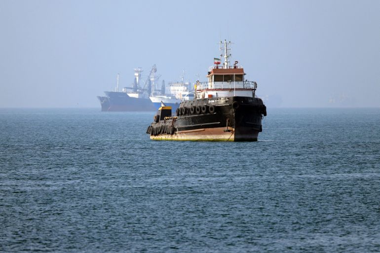 TOPSHOT - In this picture obtained from Iran's ISNA news agency on May 4, 2026, the Iran-flagged tugboat Basim sails near a ship anchored in the Strait of Hormuz off Bandar Abbas in southern Iran.
