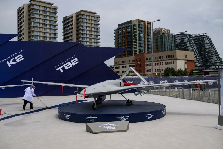afp_69fa20b4f30f-1778000053 An employee sweeps the floor near a Bayraktar TB2 drone displayed during the opening day of the SAHA EXPO 2024, an International Defence and Aerospace exhibition, in Istanbul on May 5, 2026. (Photo by Yasin AKGUL / AFP)