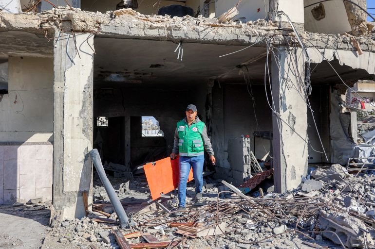 afp_69fb1221826a-1778061857 A first responder walks with a stretcher at the scene of an Israeli strike on a police station in Gaza City on May 5, 2026.