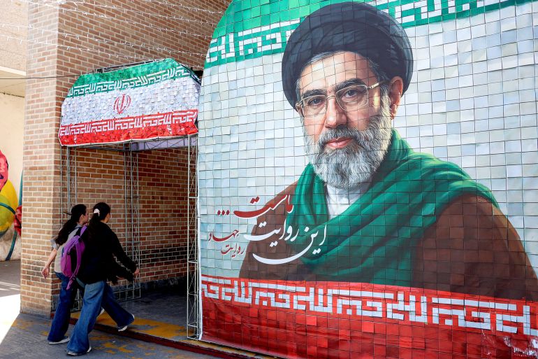 afp_69feea8fb5b5-1778313871-1 TOPSHOT - Women walk past a banner depicting Iran's current supreme leader Ayatollah Mojtaba Khamenei along a street Tehran on May 6, 2026.