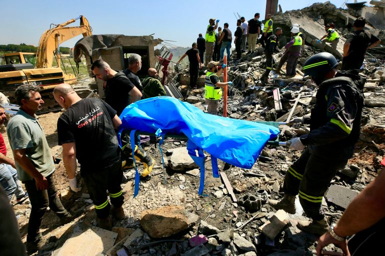 First responders carry a body on a stretcher at the site of an Israeli airstrike in the southern village of Saksakieh on May 9, 2026.