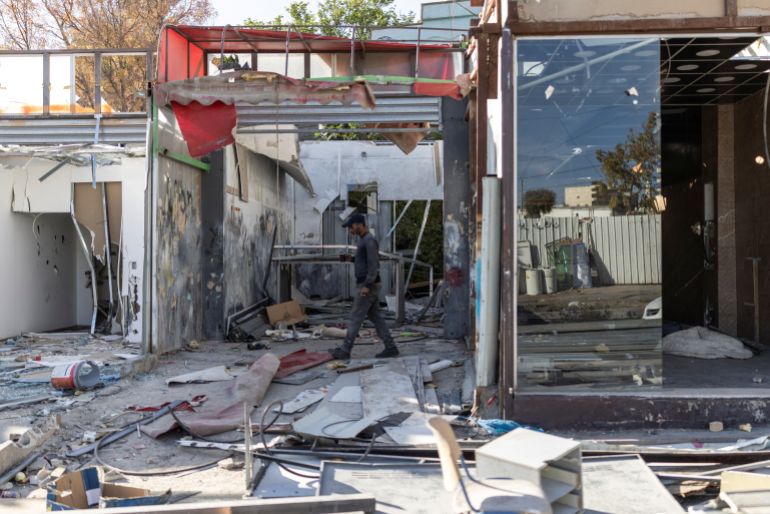 A Palestinian worker walks past shops he has demolished, ahead of the arrival of an Israeli army demolition team, in the Israeli-occupied Palestinian West Bank town of al-Eizariya, bordering East Jerusalem on May 10, 2026.