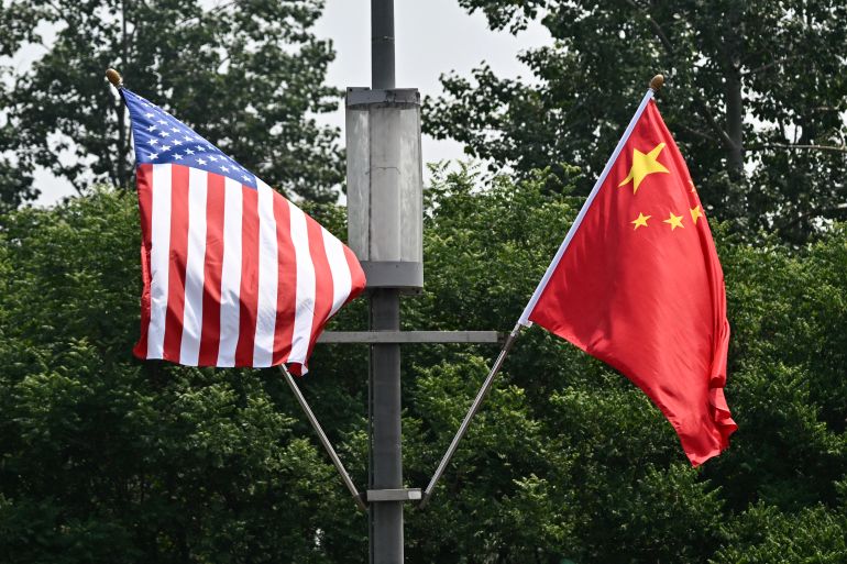 afp_6a04191a7712-1778653466 The national flags of the United States and China hang on a highway, on May 13, 2026, ahead of a visit by US President Donald Trump.
