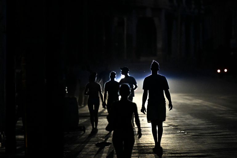 afp_6a0646d89452-1778796248 People walk on a street during a blackout in Havana on May 13, 2026.