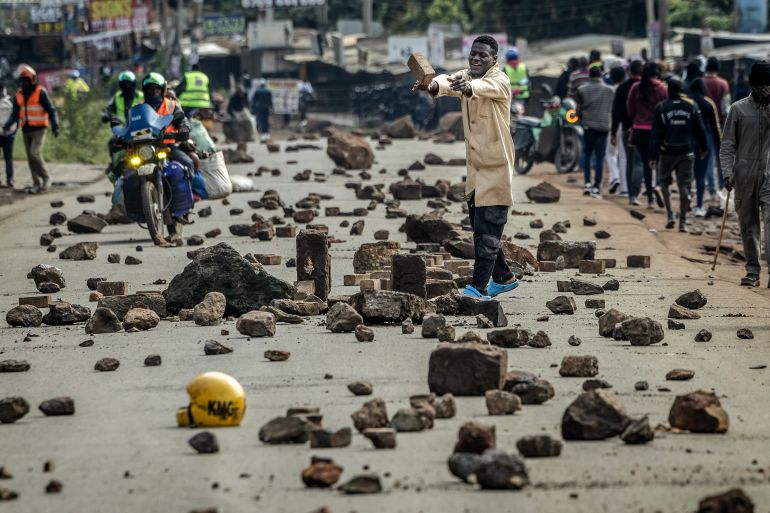 afp_6a0ae20bd84a-1779098123 A protester blocks a road with stones to prevent traffic from passing during a nationwide transport strike over rising fuel prices in Nairobi on May 18, 2026.