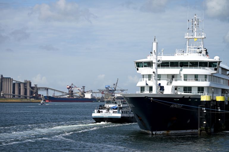 afp_6a0b1960bb09-1779112288 The "Immunity" inland tanker (L) sails past the docked Dutch Hantavirus-hit cruise ship MV Hondius at the port of Rotterdam on May 18, 2026.