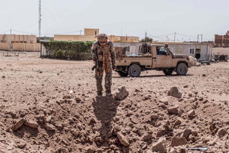 afp_6a0e9a6a0e07-1779341930 A soldier from the National Front for the Liberation of Azawad (FLA) inspects a crater in Kidal on May 14, 2026 caused by aerial bombardment from Malian Armed Forces (FAMA).