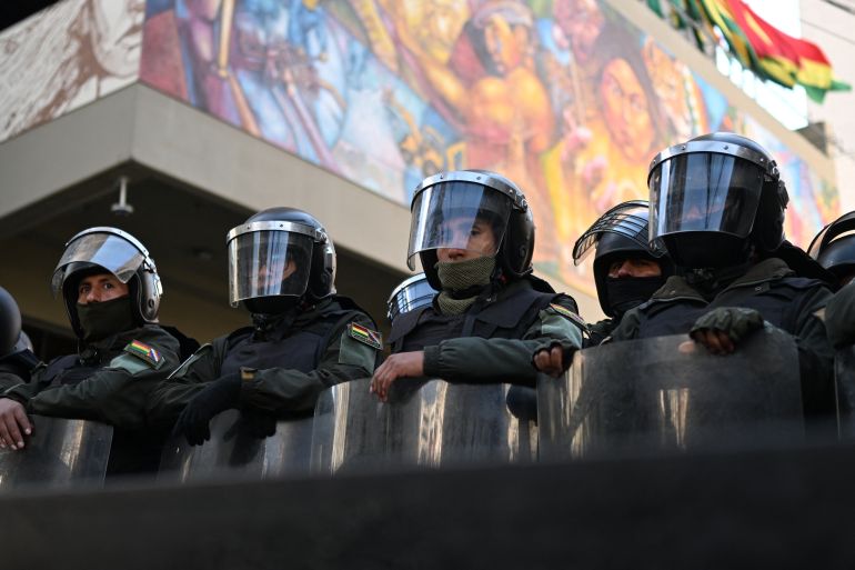 Riot police stand guard at the headquarters of the Central Bank during a march organized by the Bolivian Workers' Center (COB), calling for the resignation of President Rodrigo Paz, in La Paz on May 21, 2026.