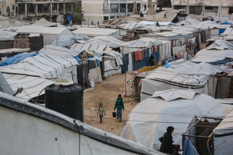 Palestinians make their way through makeshift shelters in Khan Yunis in the southern Gaza Strip on May 21, 2026.