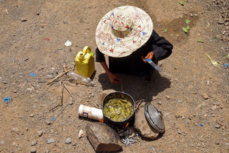 afp_6a1333813cf4-1779643265 Displaced Yemeni woman Saeedah Mohammed boils tree leaves to feed her grand-children outside their makeshift tent in the Al-Manij displacement camp, near the city of Taez in Yemen's southwest, on May 21, 2026.