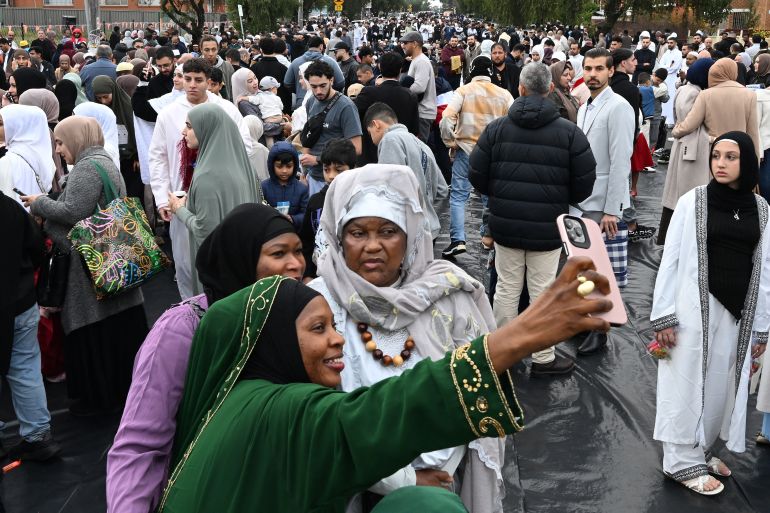 A Muslim family takes selfies outside the Lakemba Mosque, after the Eid al-Adha prayer in western Sydney, Australia, on May 27, 2026.
