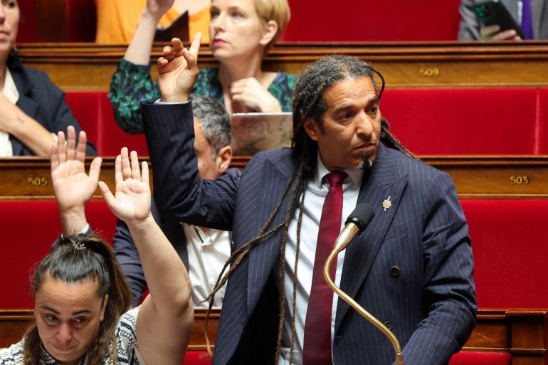 Ecologiste et Social's MP Sabrina Sebaihi (L), French politician Clementine Autain (C) and Ecologiste et Social's MP Steevy Gustave (C/R) vote rising their hands during a session to debate a proposed bill aimed at abolishing the slavery-related laws at The National Assembly, France's lower house parliament, in Paris on May 28, 2026.