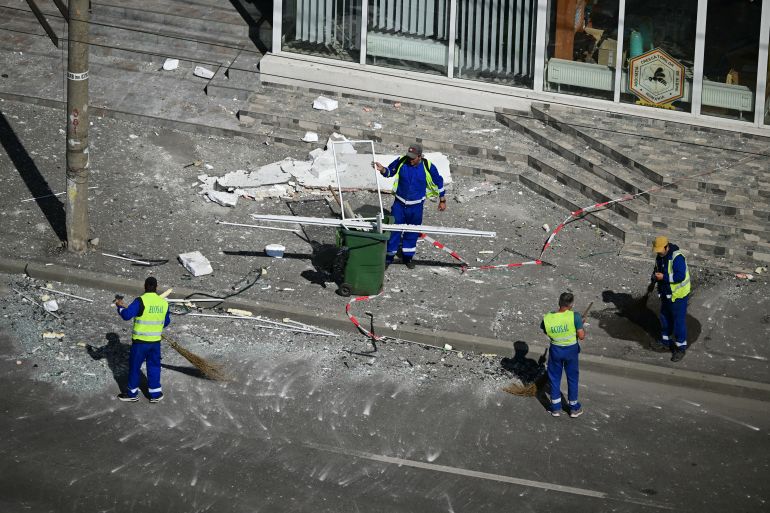 Municipal workers clear debris from the street after a Russian drone struck an apartment building in Galati, eastern Romania.