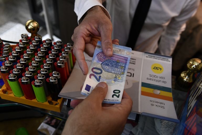 A man uses cash to pay for items while shopping in Milan, Italy, October 2, 2020. Picture taken October 2, 2020. REUTERS/Flavio Lo Scalzo