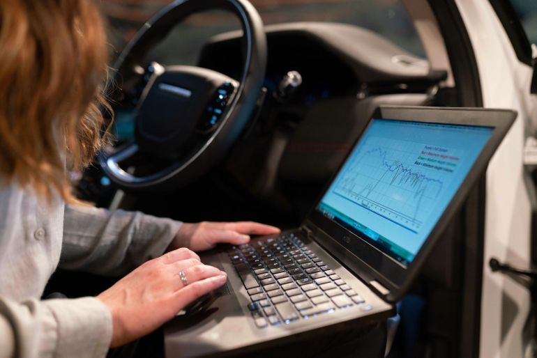 alsyant-5-1778924568 Female engineer using laptop to analyze vehicle data inside a car for testing purposes.