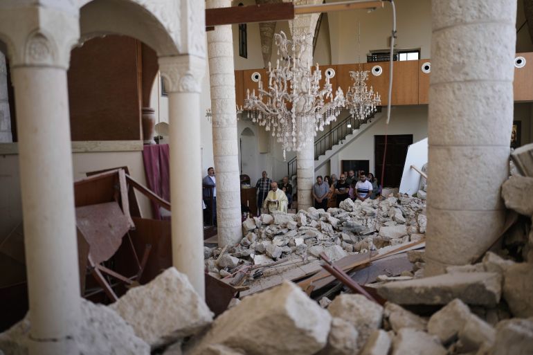 Worshippers gather for Easter Mass inside the ruins of St. George Melkite Catholic Church in Dardghaya, southern Lebanon, Sunday, April 20, 2025, after the church was heavily damaged in an Israeli airstrike earlier in the conflict. (AP Photo/Hassan Ammar)