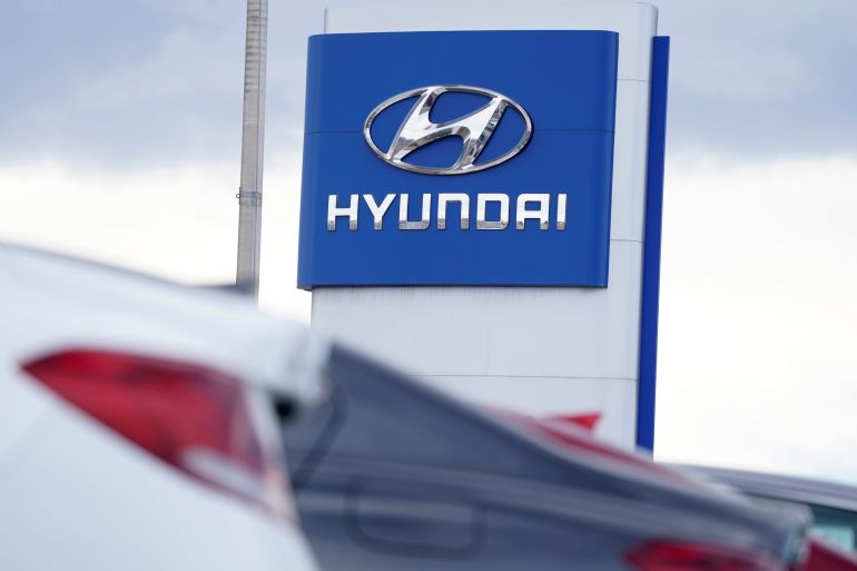 The company logo hangs over a long row of unsold 2021 Genesis sedans as they sit at a Hyundai dealership Sunday, Dec. 20, 2020, in Centennial, Colo. (AP Photo/David Zalubowski)