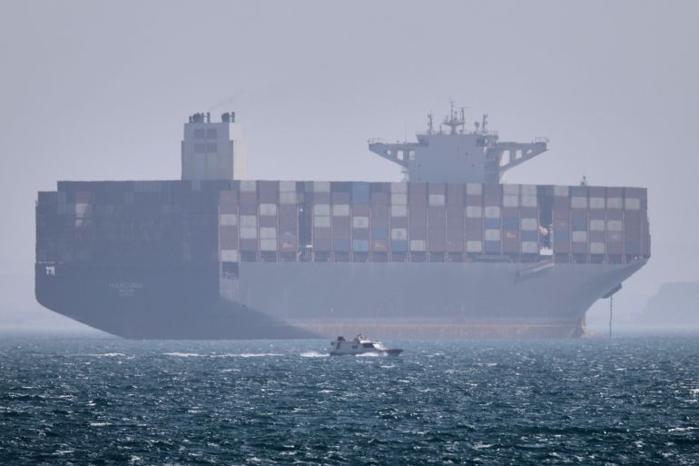 ap_69fc367e2fc87-1778136702-2 A container ship sits at anchor as a small motorboat passes in the foreground in the Strait of Hormuz off Bandar Abbas, Iran, Saturday, May 2, 2026. (Amirhosein Khorgooi/ISNA via AP)