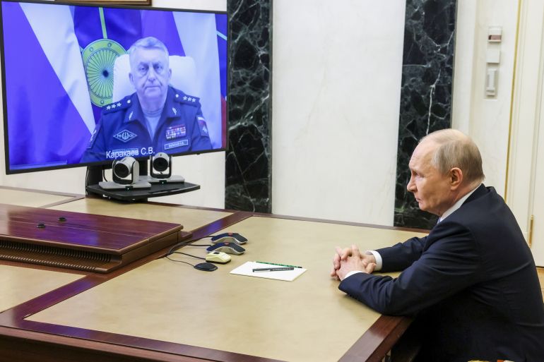 Russian Strategic Missile Forces chief, Col. Gen. Sergei Karakayev, left on the screen, reports to President Vladimir Putin on a successful test launch of the Sarmat intercontinental ballistic missile at the Kremlin in Moscow, Tuesday, May 12, 2026. (Mikhail Metzel/Sputnik, Kremlin Pool Photo via AP)
