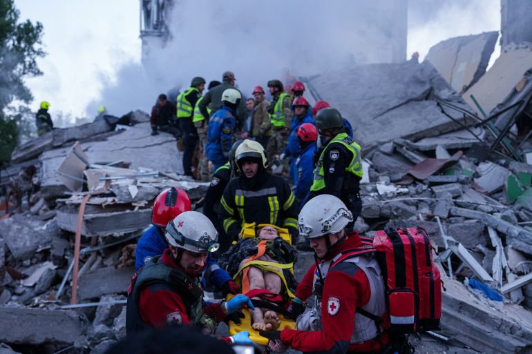 ap_6a058941ce50a-1778747713 Rescue workers carry an injured woman on a stretcher from a house heavily damaged after a Russian strike on residential neighbourhood in Kyiv, Ukraine, on Thursday, May 14, 2026. (AP Photo/Evgeniy Maloletka)