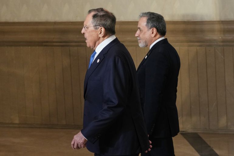 ap_6a05eefd32079-1778773757 Russia's Foreign Minister Sergey Lavrov, left, and Iranian Foreign Minister Abbas Araghchi return to their seats after a group photo with representatives of partner countries at a two-day Foreign Ministers meeting of BRICS nations in New Delhi, India, Thursday, May 14, 2026. (AP Photo/Manish Swarup)