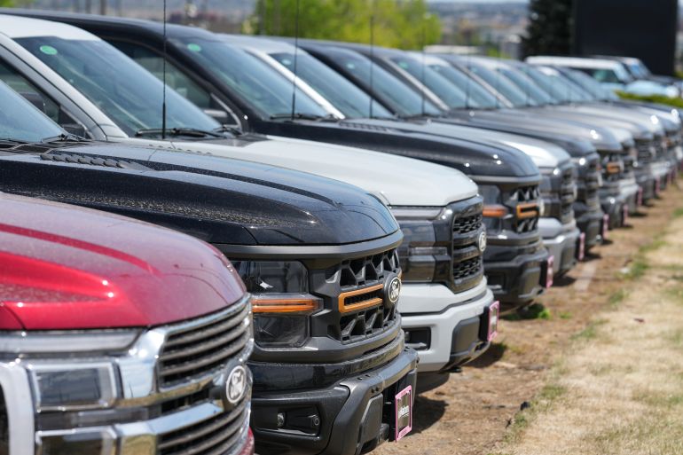 Unsold 2026 F150 pickup trucks sit in a long line outside a Ford agency Sunday, April 12, 2026, in Centennial, Colo. (AP Photo/David Zalubowski)