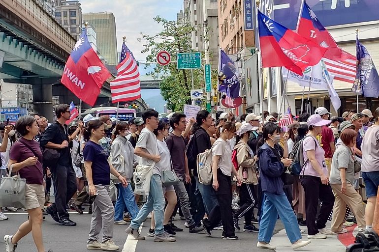 Taiwanese people hold flags of Taiwan and the U.S. during a march to support Taiwan's security in Taipei, Taiwan, Saturday, May 23, 2026. (AP Photo/Chiang Ying-ying)