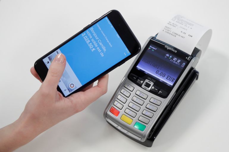 An illustration photo shows an employee of Orange Bank pretending to pay with nfc system without contact, using Orange bank credit card at the Orange Bank headquarters in Montreuil near Paris, France, October 27, 2017. Picture taken October 27, 2017. REUTERS/Charles Platiau