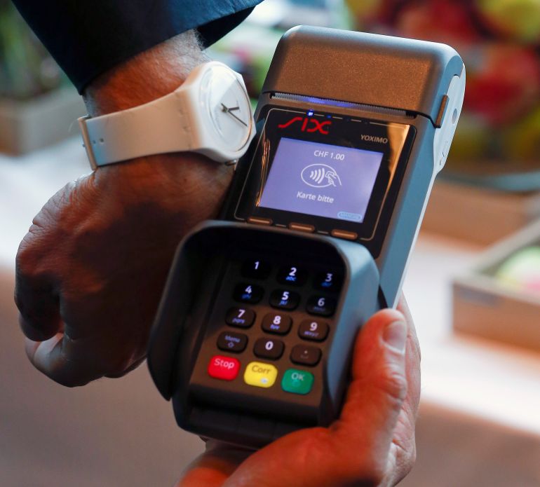 A model shows a pay-by-the-wrist contactless payment using a Swatch Bellamy watch via Visa credit card system during a presentation of Swiss watch manufacturer Swatch in Zurich, Switzerland June 16, 2016. REUTERS/Arnd Wiegmann