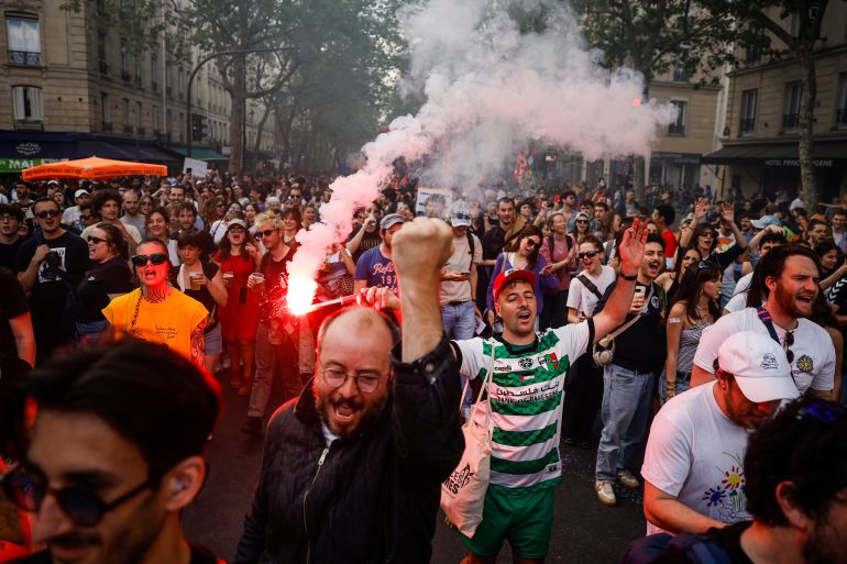 epa12927027 Protesters light flares as they take part in the annual May Day demonstration in Paris, France, 01 May 2026. Labor Day, also known as International Workers' Day or May Day, is observed annually on 01 May worldwide to celebrate the economic and social achievements of workers and fight for laborers' rights. EPA/YOAN VALAT