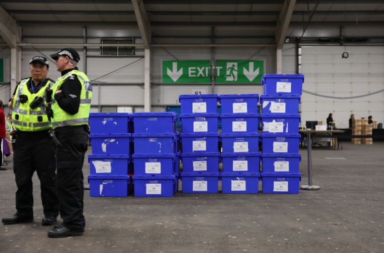 epa_69fdc3fb9bc7-1778238459 epa12940792 Police officers stand next to ballot boxes during the election count of the Scottish Parliamentary elections at the Royal Highland Centre in Edinburgh, Scotland, Britain, 08 May 2026. Voters went to the polls on 07 May to elect 129 members to the Scottish Parliament. EPA/ADAM VAUGHAN