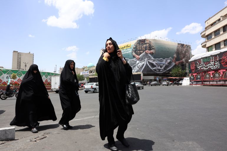 epa12940976 Iranian women walk next to a huge anti-US billboard carrying a sentence reading in Persian ’The Strait of Hormuz remains closed’ at the Engelab (Revolution) square in Tehran, Iran, 08 May 2026. Iran and US exchanged fire in the Strait of Hormuz amid a ceasefire. EPA/ABEDIN TAHERKENAREH