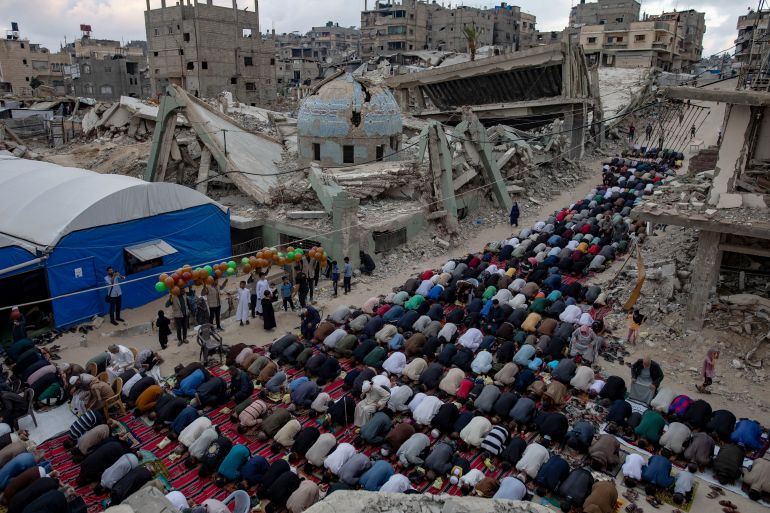 epa12996589 Displaced Palestinians perform Eid al-Adha prayers beside the ruins of Al-Huda Mosque in Khan Younis, southern Gaza Strip, 27 May 2026. Eid al-Adha, also known as the Feast of Sacrifice, coincides with the annual Hajj pilgrimage to Mecca and is traditionally marked by the sacrifice of livestock and the distribution of meat among family, friends and those in need. EPA/HAITHAM IMAD