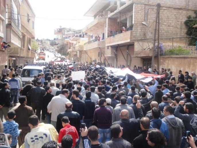 Protesters hold a Syrian flag during a demonstration in Zabadani, near Damascus April 22, 2011. Syrian security forces shot dead dozens of protesters on Friday, rights activists said, the bloodiest day in a month of escalating demonstrations against the rule of President Bashar al-Assad. Protests swept the country of 20 million people, from the Mediterranean city of Banias to the eastern towns of Deir al-Zor and Qamishli.
