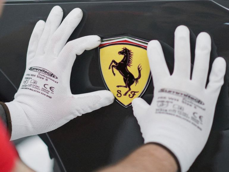 FILE PHOTO: A Ferrari logo is installed on a Ferrari at the company's new 'e-building' facility, where the luxury sports car maker is testing lines before an expected start of production in early 2025, in Maranello, Italy, June 21, 2024. REUTERS/Daniele Mascolo/File Photo