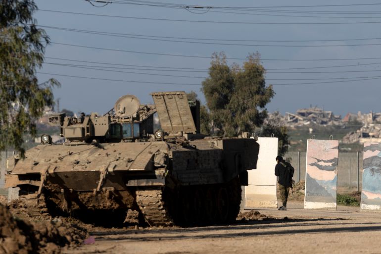SOUTHERN ISRAEL, ISRAEL - JANUARY 16: An Israeli soldier stands near an armored personnel carrier near the border with the northern Gaza Strip as seen from a position on the Israeli side of the border on January 16, 2026 in Southern Israel, Israel. On Wednesday, US envoy Steve Witkoff announced the start of the 20-point Gaza ceasefire plan's second phase, with a focus on reconstruction and demilitarization, and a "transitional technocratic Palestinian administration in Gaza." Israel has continued to call for the further demilitarization of Hamas and the return of the remains of the last hostage remaining in Gaza, the 24-year-old police officer Ran Gvili. (Photo by Amir Levy/Getty Images)