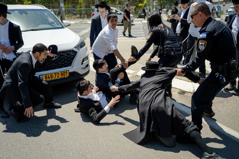 RAMAT GAN, ISRAEL - APRIL 12: Ultra-Orthodox Jews protest against the military draft outside a recruitment center on April 12, 2026 in Ramat Gan, Israel. The government has been trying to pass a new law restoring the exemption of Ultra-orthodox (Haredi) men from the country's conscription requirements, following a ruling by the High Court that found the longstanding exemption illegal. The Court is currently hearing a contempt of court case against the government for failing to enforce the mandatory conscription after the exemption law for Haredi expired in June 2023. (Photo by Erik Marmor/Getty Images)