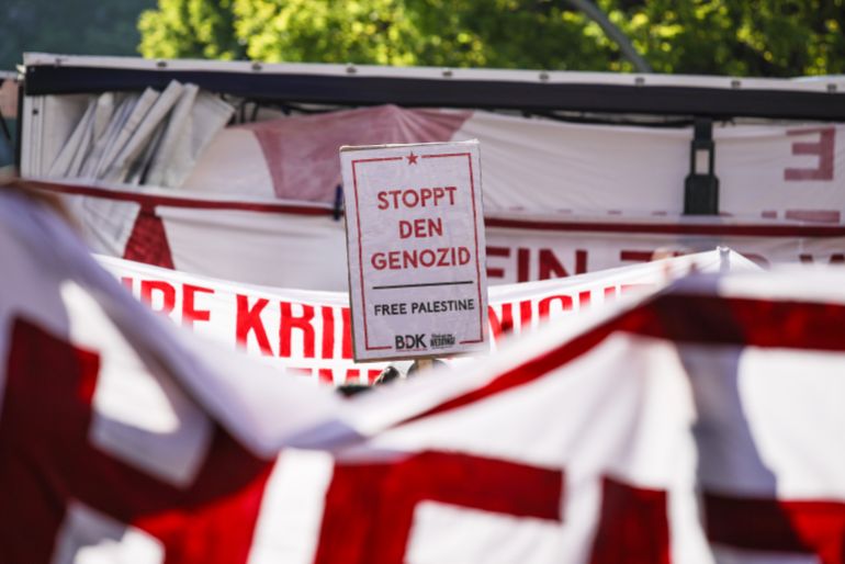 BERLIN, GERMANY - MAY 1: A protester holds a banner reading "Stop the genocide, free Palestine" as people gather for the "Revolutionary May 1st Protest" ("Revolitionre 1. Mai Demo") in Kreuzberg district on May 1, 2026 in Berlin, Germany. Over 5,000 police officers are on hand in the city today among a wide variety of events marking the traditional May Day gatherings and protest marches. (Photo by Omer Messinger/Getty Images)