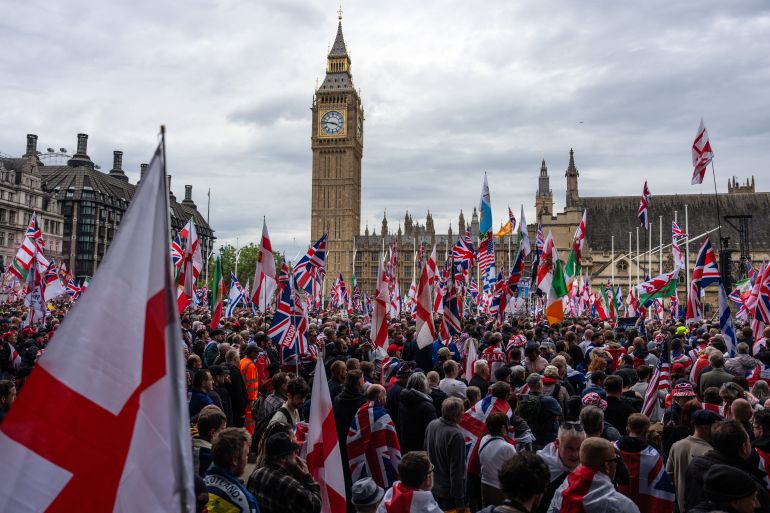 LONDON, ENGLAND - MAY 16: People take part in the "Unite the Kingdom" rally on May 16, 2026 in London, England. The far-right "Unite the Kingdom" rally, organised by Tommy Robinson is to be held under strict Public Order Act conditions with demonstrators legally confined to a specific south-bound corridor from Kingsway to Parliament Square between late morning and early evening. To prevent clashes with a concurrent counter-protest, the Metropolitan Police has launched an unprecedented £4.5 million security operation deploying over 4,000 officers. The operation is using live facial recognition, armoured vehicles, and stringent hate speech monitoring, while the Home Office has barred multiple international far-right speakers from entering Britain. (Photo by Carl Court/Getty Images)