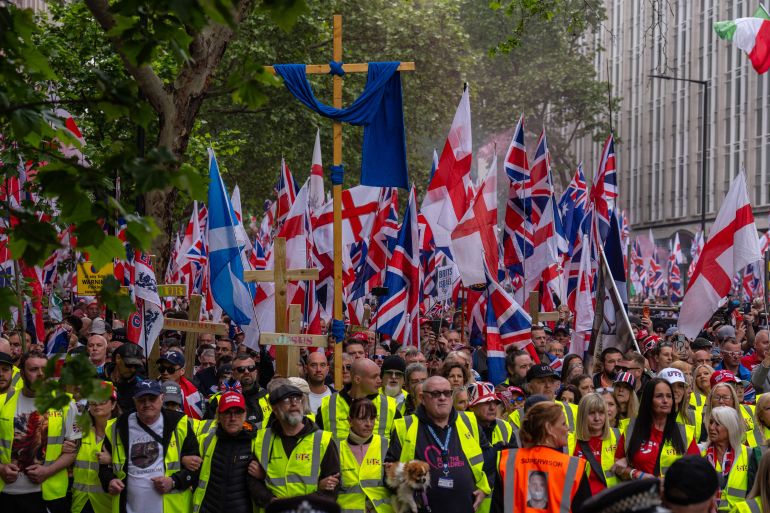 LONDON, ENGLAND - MAY 16: People take part in the "Unite the Kingdom" rally on May 16, 2026 in London, England. The far-right "Unite the Kingdom" rally, organised by Tommy Robinson is to be held under strict Public Order Act conditions with demonstrators legally confined to a specific south-bound corridor from Kingsway to Parliament Square between late morning and early evening. To prevent clashes with a concurrent counter-protest, the Metropolitan Police has launched an unprecedented £4.5 million security operation deploying over 4,000 officers. The operation is using live facial recognition, armoured vehicles, and stringent hate speech monitoring, while the Home Office has barred multiple international far-right speakers from entering Britain. (Photo by Carl Court/Getty Images)
