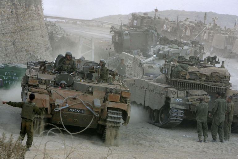 getty_6a0ecca718-1779354791-1 LEBANESE BORDER, ISRAEL - AUGUST 17: An Israeli soldier directs an armored personnel carrier into place on its return from an early morning patrol in southern Lebanon, at a forward base packed with APC's and tanks August 17, 2006 on Israel's border with Lebanon. Israel is consolidating its positions in southern Lebanon, bringing its troops closer to its border, as Lebanese troops, backed by tanks and armored vehicles, began to deploy south of the Litani River in line with a United Nations cease-fire plan to end fighting between Israel and Hezbollah. (Photo by David Silverman/Getty Images)