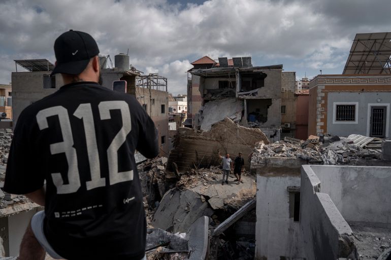 getty_6a18156f01-1779963247 TYRE, LEBANON - MAY 26: Two neighbors take photos and videos of the damage after an Israeli airstrike on May 26, 2026 in Tyre, Lebanon. Israel has intensified airstrikes on the southern Lebanese coastal city of Tyre, in the Jabal Amel region of Southern Lebanon, following an order from Prime Minister Benjamin Netanyahu to intensify the blows and crush Hezbollah. The escalation comes as a surge in Hezbollah explosive drone attacks has heavily restricted Israeli military activity and caused casualties among its troops. (Photo by Adri Salido/Getty Images)