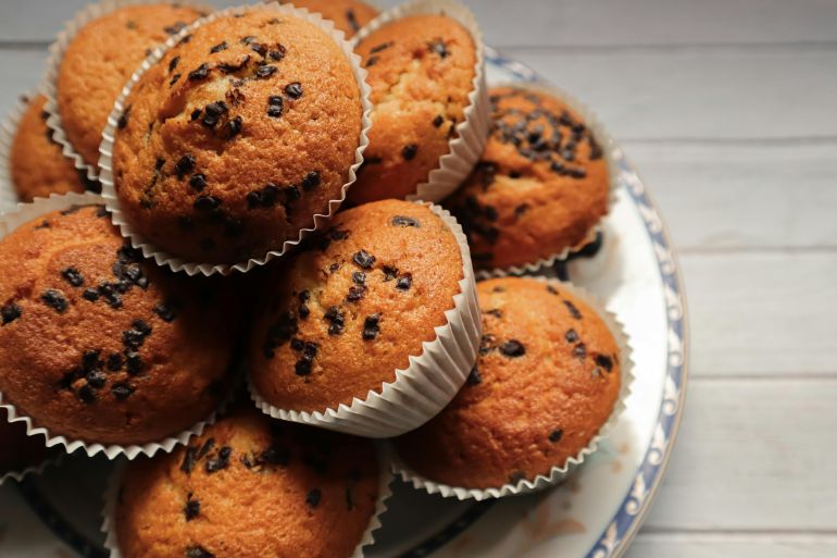 Delicious chocolate chip muffins on a ceramic plate, perfect for dessert or snack.