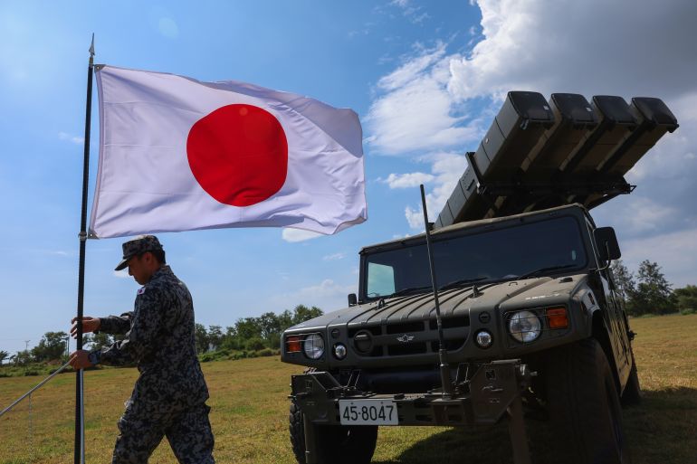 SAN ANTONIO, ZAMBALES, PHILIPPINES - APRIL 28: A Japanese Self-Defense Forces personnel puts a Japanese flag in front of a surface-to-air guided missile system, during an Integrated Air and Missile Defense (IAMD) drill, as part of the ongoing Balikatan (Shoulder-Shoulder) multinational exercise, at a naval base in San Antonio, Zambales, Philippines, on April 28, 2026. The IAMD exercise, which sees the deployment of troops and missile systems from the United States and Japan, comes at a time of escalating tensions in the disputed South China Sea and the Taiwan Strait, with the Chinese People's Liberation Army increasing military activities in the water and Beijing denouncing Tokyo's strengthened defense cooperation with the Philippines. (Photo by Daniel Ceng/Anadolu via Getty Images)