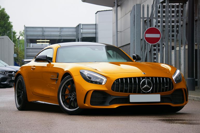 Gold luxury sports car parked on a UK street, showcasing sleek design and automotive elegance.